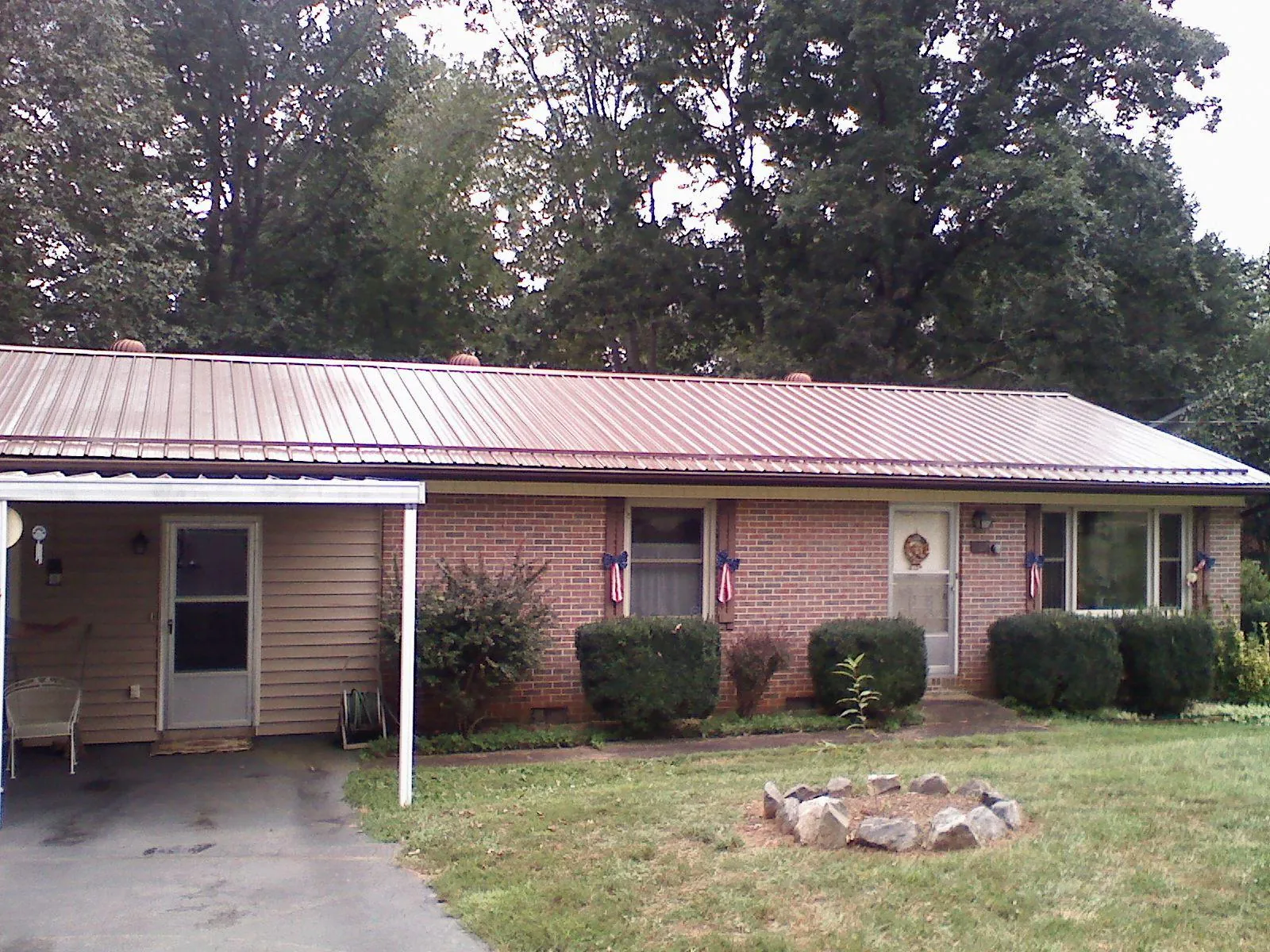 Bronze metal roof and carport on a brick ranch home — Roof Repair work by our crew in Mount Perry